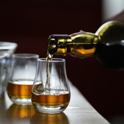 A glass of whisky is poured into a glass.