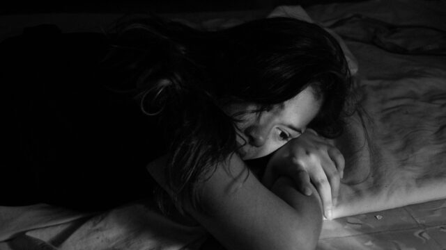 A woman lays in bed.