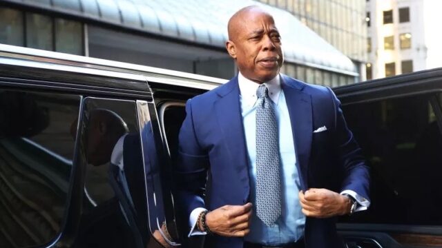 NYC mayor Eric Adams steps out of vehicle.
