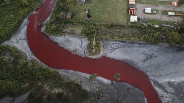 The Sarandí river in Argentina dyed red from pollutant.