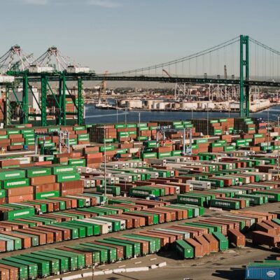 Shipping containers line a shipping port at harbor.