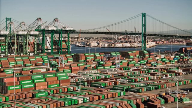 Shipping containers line a shipping port at harbor.