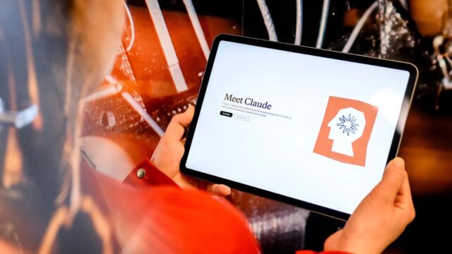 Student holds tablet with Claude AI.