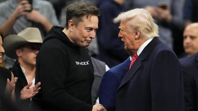 Elon Musk shakes Donald Trump's hand.