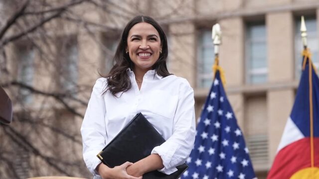 Rep. Alexandria Ocasio-Cortez (D-NY) smiles after speaking during a stop of their “Fighting Oligarchy” tour that filled Civic Center Park on Friday, March 21, 2025, in Denver. (AP Photo/David Zalubowski)