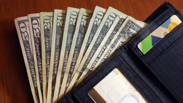 A stack of 20 dollar bills spilling out of a wallet (AP Photo/Elise Amendola, File)AP