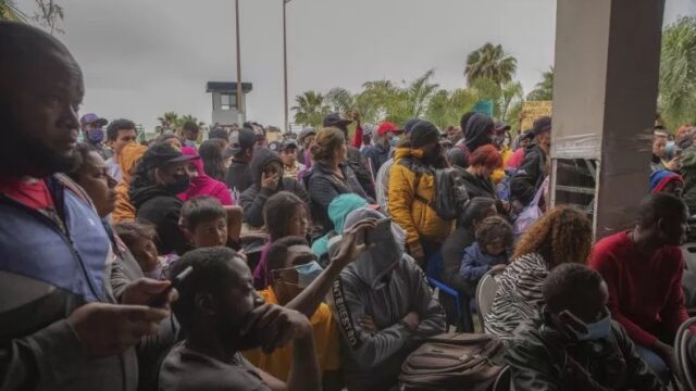 A stock image of migrants gathering for a rally at the U.S.-Mexico border. Aimee Melo/dpa via AP
