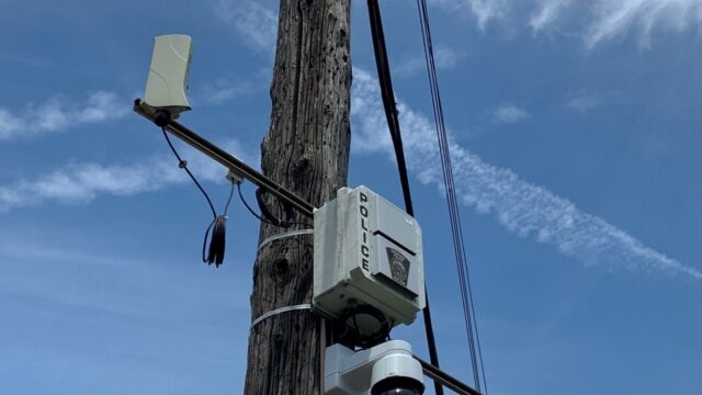 A utility pole in Cleveland with a camera attatched.