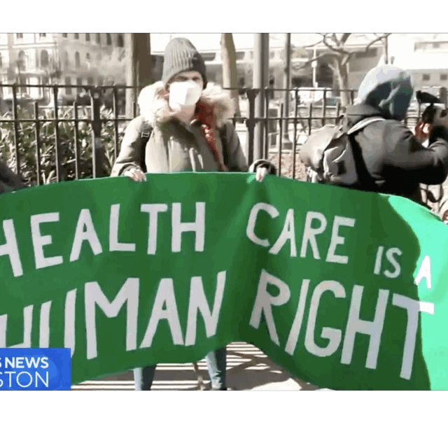 Protestors holding a sign that reads: 