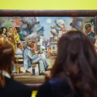 Visitors admire artwork by Allan Rohan Crite at the opening of the “Allan Rohan Crite: Griot of Boston” exhibition at the Boston Athenaeum.