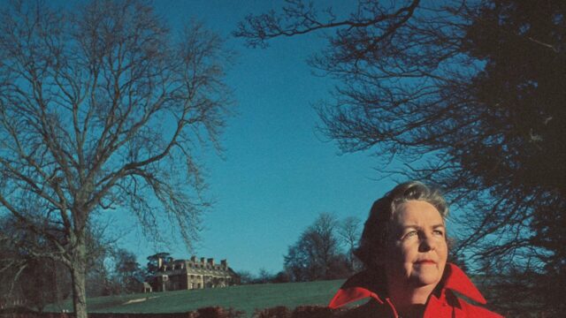 Kaplan standing in front of a house