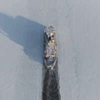 The icebreaker makes a route in the ice fields. Air view.