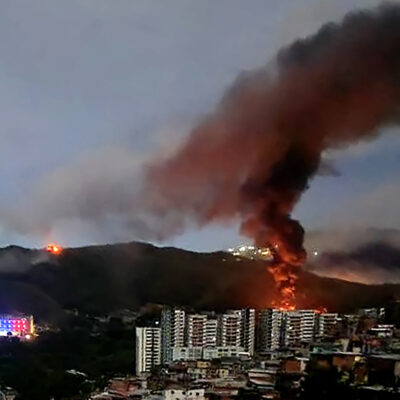 TOPSHOT - Fire at Fuerte Tiuna, Venezuela's largest military complex, is seen from a distance after a series of explosions in Caracas on January 3, 2026. (Photo by AFP via Getty Images)