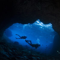 Two female scuba divers at the cave 'Buraco do Inferno' at the archipelago of Fernando de Noronha, Pernambuco state - Brazil