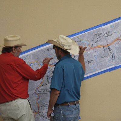 Attendees look at a marked up map of the Guadalupe River during a Texas state Senate and House Select Committees on Disaster Preparedness and Flooding public hearing, in Kerrville, Texas, Thursday, July 31, 2025. (AP Photo/Eric Gay)