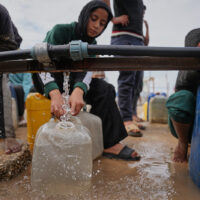 A Palestinian youth collects water at a desalination plant in Khan Younis, southern Gaza Strip, Friday, Feb. 6, 2026. (AP Photo/Abdel Kareem Hana)