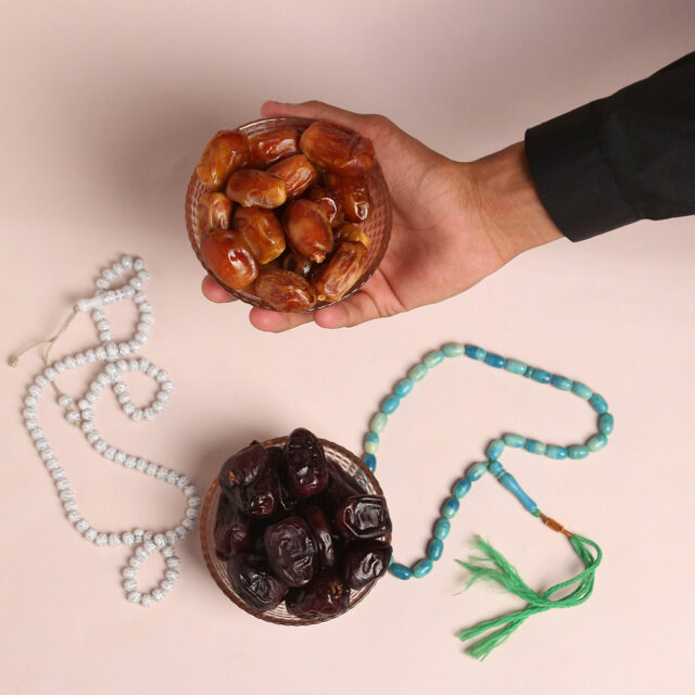 An individual places a bowl of dates next to prayer beads. (Photo by Rauf Alvi/Unsplash/Creative Commons)