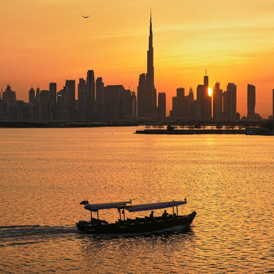 A man steers a boat during sunset, as the city skyline with Burj Khalifa is seen in the background at Dubai Creek Harbour in Dubai, United Arab Emirates, Wednesday, March 11, 2026. (AP Photo/Fatima Shbair)