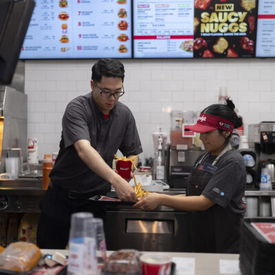 Lawrence Cheng, left, whose family owns seven Wendy's locations south of Los Angeles, works with part-time employee Adriana Ruiz at his Wendy's restaurant in Fountain Valley, Calif., June 20, 2024. When California’s minimum wage increase went into effect in April, fast food workers across the state went from making $16 to $20 overnight. It's already having an impact, according to local operators for major fast food chains, who say they are reducing worker hours and raising menu prices as the sudden increase in labor costs leaves them scrambling for solutions. (AP Photo/Jae C. Hong)