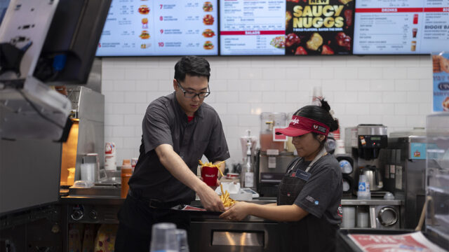 Lawrence Cheng, left, whose family owns seven Wendy's locations south of Los Angeles, works with part-time employee Adriana Ruiz at his Wendy's restaurant in Fountain Valley, Calif., June 20, 2024. When California’s minimum wage increase went into effect in April, fast food workers across the state went from making $16 to $20 overnight. It's already having an impact, according to local operators for major fast food chains, who say they are reducing worker hours and raising menu prices as the sudden increase in labor costs leaves them scrambling for solutions. (AP Photo/Jae C. Hong)