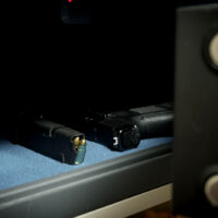 Gun and ammo magazine in the safe, front view, close up photo