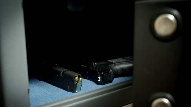 Gun and ammo magazine in the safe, front view, close up photo