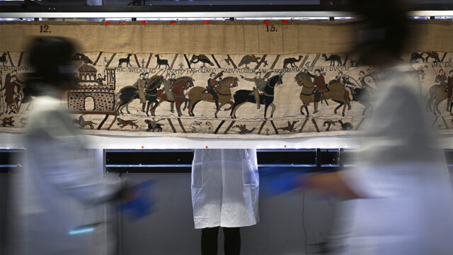 Workers and volunteers prepare to pack the Bayeux tapestry to transfer to the British Museum, at the Bayeux Tapestry Museum, in Bayeux, northwestern France, Thursday, Sept. 18, 2025. (Lou Benoist, Pool via AP)