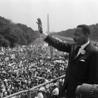 US civil rights leader Martin Luther King (C) waves to supporters on August 28, 1963 on the Mall in Washington DC (Washington Monument in background) during the 