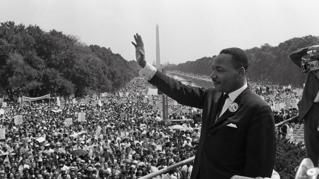 US civil rights leader Martin Luther King (C) waves to supporters on August 28, 1963 on the Mall in Washington DC (Washington Monument in background) during the 