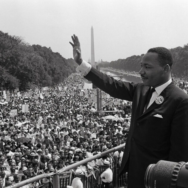 US civil rights leader Martin Luther King (C) waves to supporters on August 28, 1963 on the Mall in Washington DC (Washington Monument in background) during the 