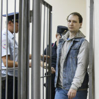 Robert Gilman, a 28-year-old former US Marine already serving a prison sentence for attacking a police officer while drunk and now facing new assault charges, is escorted before a hearing at Central District Court in Voronezh, Russia. Andrey Arhipov / Sputnik via AP