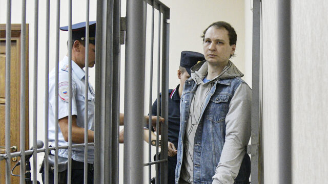 Robert Gilman, a 28-year-old former US Marine already serving a prison sentence for attacking a police officer while drunk and now facing new assault charges, is escorted before a hearing at Central District Court in Voronezh, Russia. Andrey Arhipov / Sputnik via AP