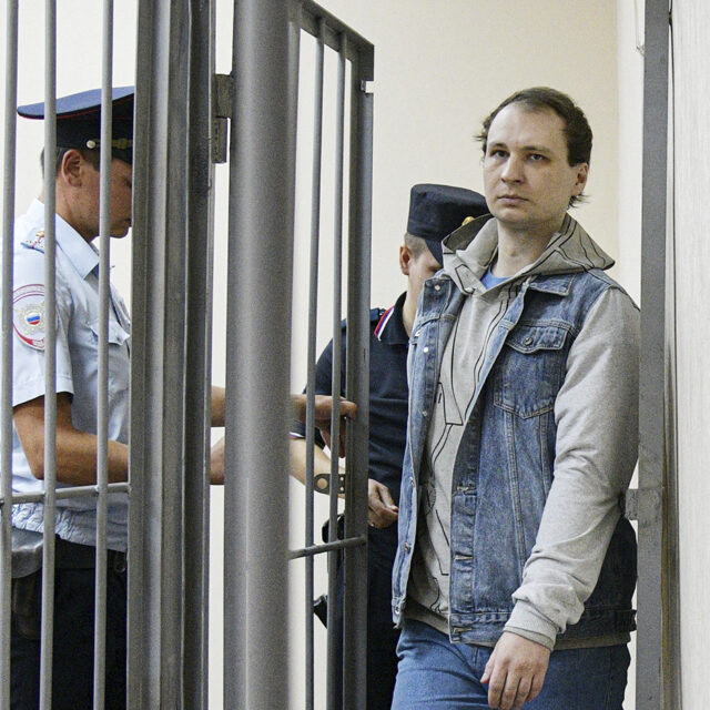 Robert Gilman, a 28-year-old former US Marine already serving a prison sentence for attacking a police officer while drunk and now facing new assault charges, is escorted before a hearing at Central District Court in Voronezh, Russia. Andrey Arhipov / Sputnik via AP